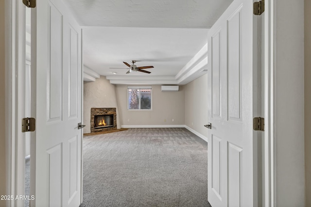 5345 E Mclellan Rd Unit 123, Mesa, AZ 85205 - unfurnished living room featuring a wall unit AC, carpet flooring, a ceiling fan, baseboards, and a fireplace