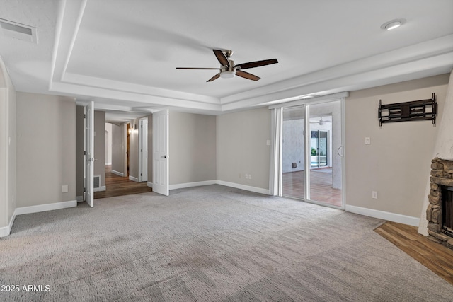 5345 E Mclellan Rd Unit 123, Mesa, AZ 85205 - unfurnished living room with a ceiling fan, a tray ceiling, baseboards, carpet, and a fireplace