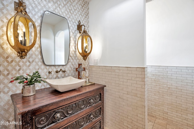 bathroom featuring vanity and tile walls