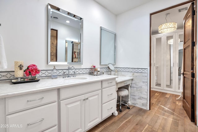 bathroom featuring hardwood / wood-style flooring, vanity, and tile walls