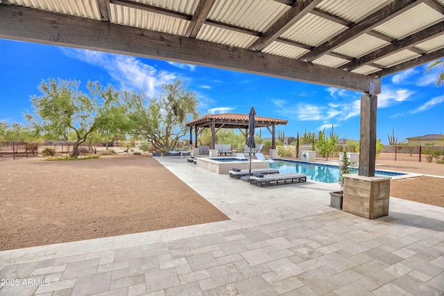 view of patio / terrace featuring a gazebo and a pool with hot tub