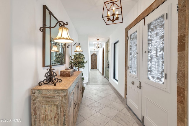 entryway with a notable chandelier and french doors