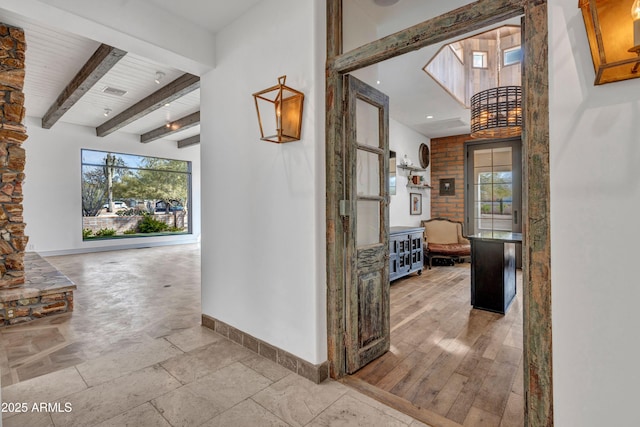 hallway with beamed ceiling and plenty of natural light