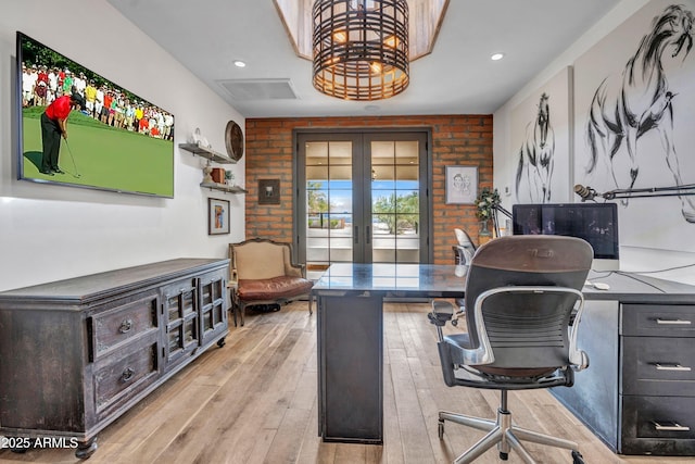 office area with french doors, brick wall, and light hardwood / wood-style flooring