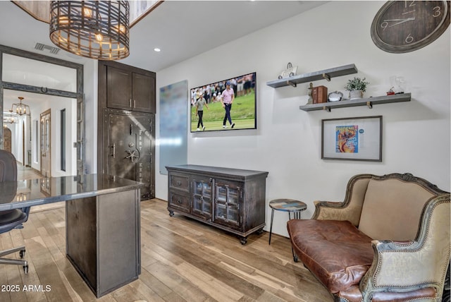 living area featuring light wood-type flooring and a chandelier