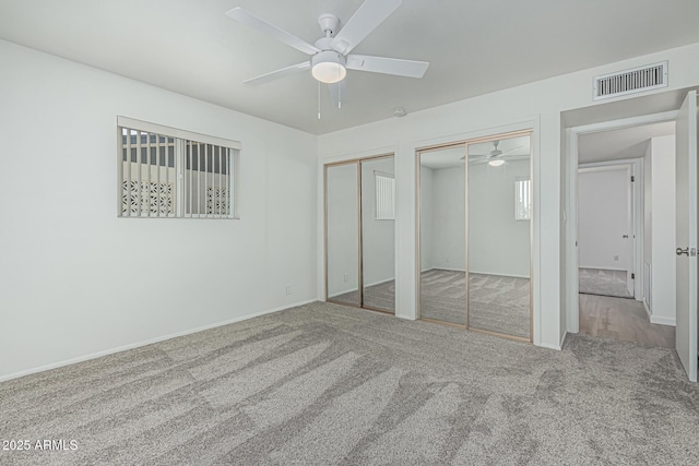 6051 E Ensenada St, Mesa, AZ 85205 - unfurnished bedroom with two closets, carpet flooring, baseboards, and a ceiling fan