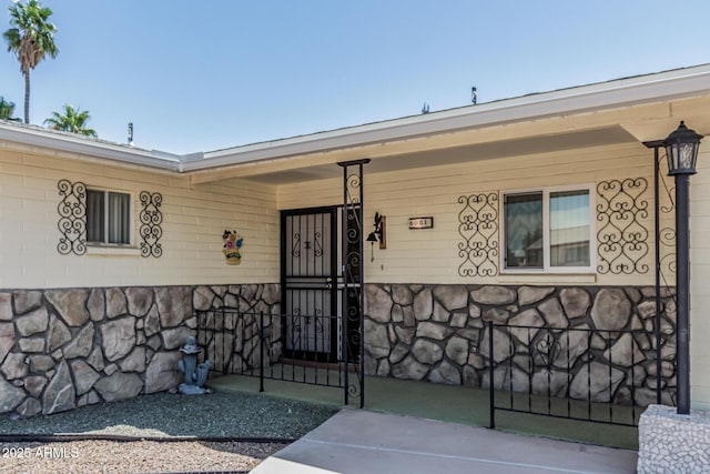6051 E Ensenada St, Mesa, AZ 85205 - doorway to property with a porch and stone siding