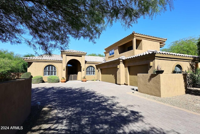 mediterranean / spanish home with a garage