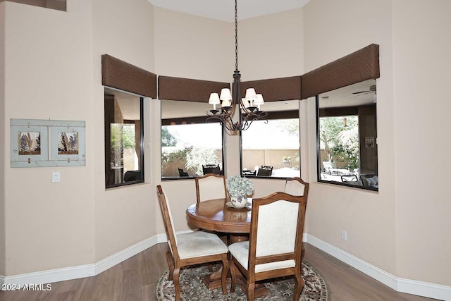 dining room with hardwood / wood-style flooring and ceiling fan with notable chandelier