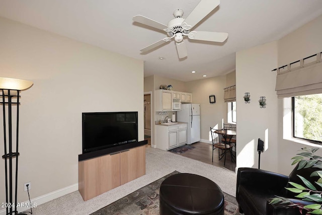 living room with ceiling fan, hardwood / wood-style flooring, and sink