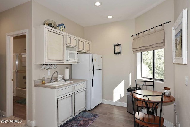 kitchen featuring light hardwood / wood-style floors, sink, and white appliances