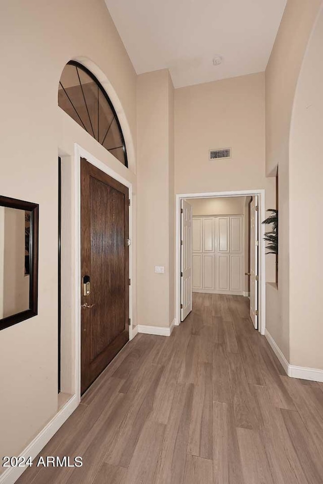 foyer entrance with a high ceiling and light hardwood / wood-style floors