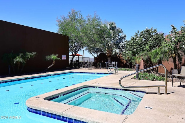 view of swimming pool featuring a community hot tub and a patio