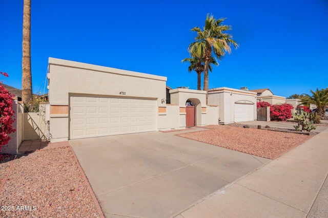 view of front facade with concrete driveway, an attached garage, and stucco siding