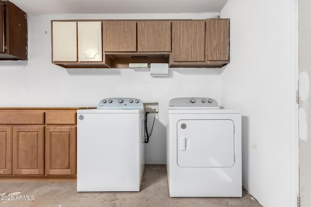 washroom with washing machine and dryer and cabinet space