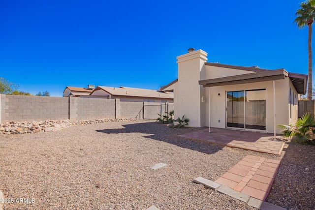 rear view of house with a patio area, a fenced backyard, and stucco siding