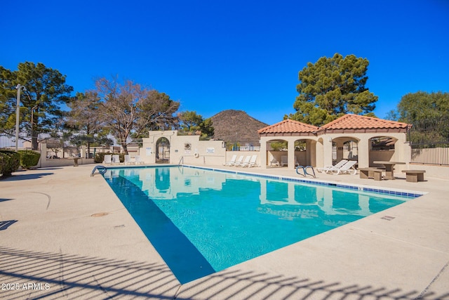 community pool featuring a patio area and fence