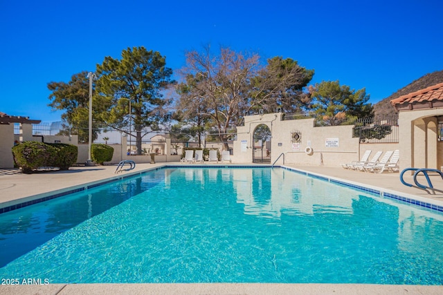 pool with fence and a patio