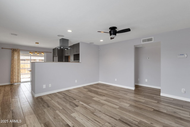 unfurnished living room featuring ceiling fan and hardwood / wood-style floors