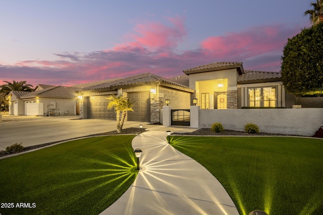 mediterranean / spanish-style house featuring a garage and a lawn