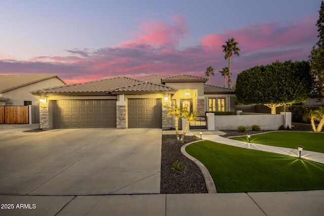 mediterranean / spanish-style house featuring a garage and a lawn