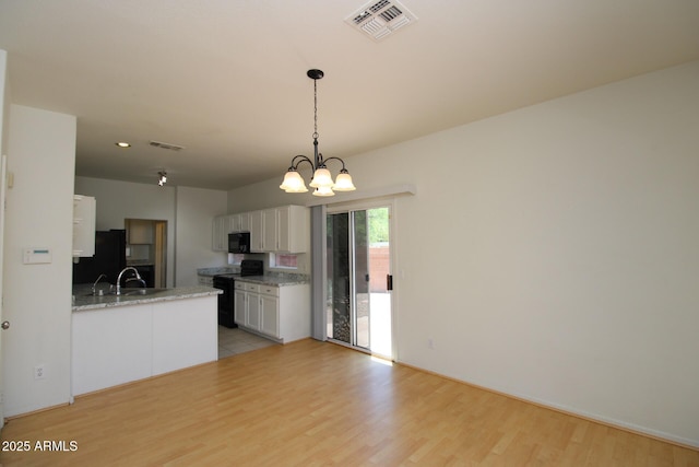 17606 N 17th Pl Unit 1096, Phoenix, AZ 85022 - kitchen featuring black appliances, light wood-style floors, white cabinets, a chandelier, and hanging light fixtures