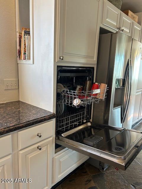 kitchen with white cabinetry, dark stone counters, stainless steel fridge with ice dispenser, and decorative backsplash