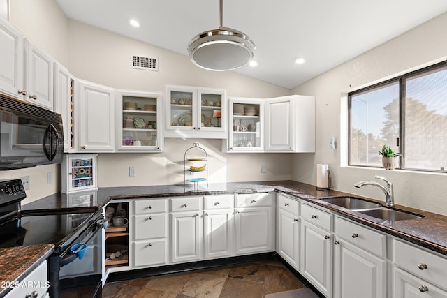 kitchen featuring sink, white cabinetry, vaulted ceiling, dark stone counters, and black appliances