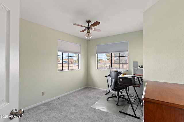 carpeted home office featuring ceiling fan