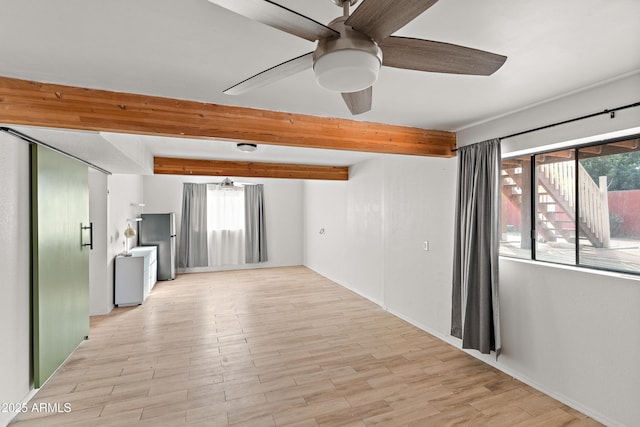 empty room with beamed ceiling, light wood-type flooring, and ceiling fan