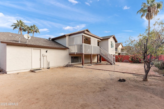 back of property with ceiling fan and a patio