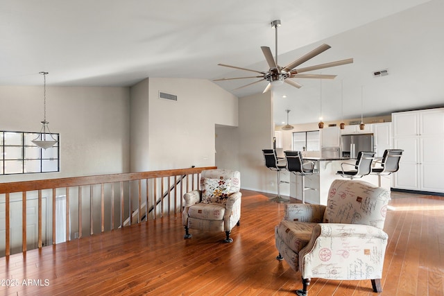 living room with hardwood / wood-style flooring, high vaulted ceiling, and ceiling fan