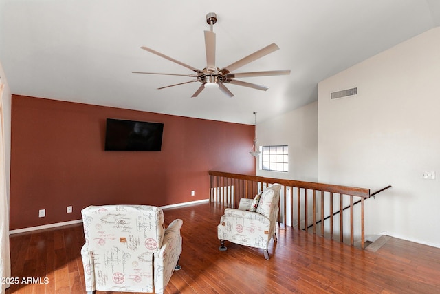 living area featuring dark wood-type flooring, ceiling fan, and vaulted ceiling