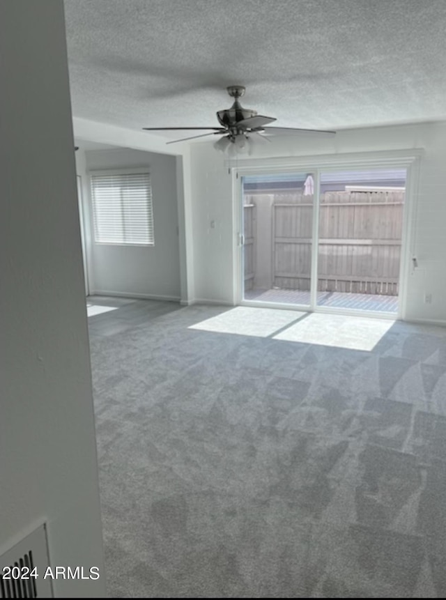 spare room with carpet flooring, a textured ceiling, and ceiling fan