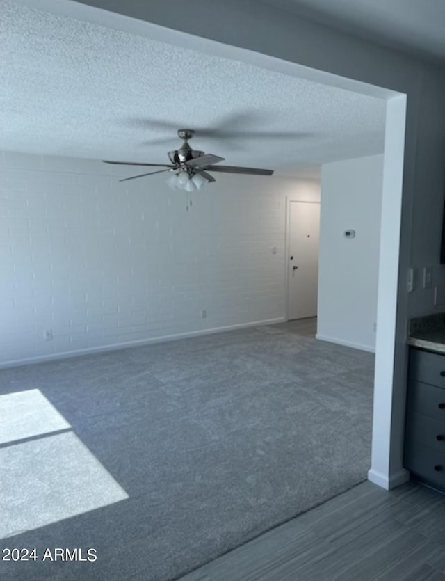 spare room featuring a textured ceiling, hardwood / wood-style flooring, and ceiling fan