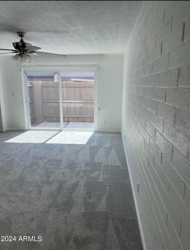 carpeted empty room with ceiling fan and a textured ceiling