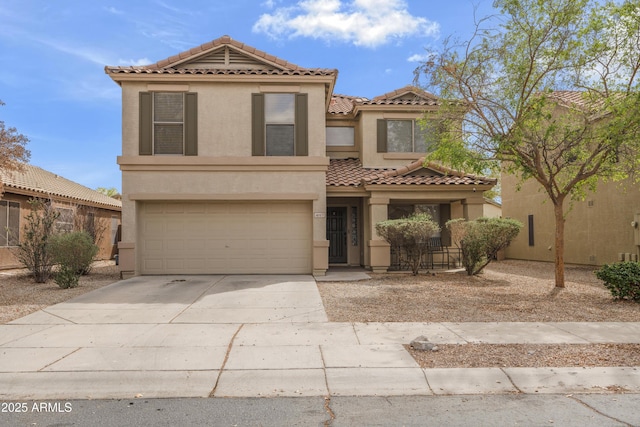 view of front of home featuring stucco siding, a tiled roof, concrete driveway, and an attached garage