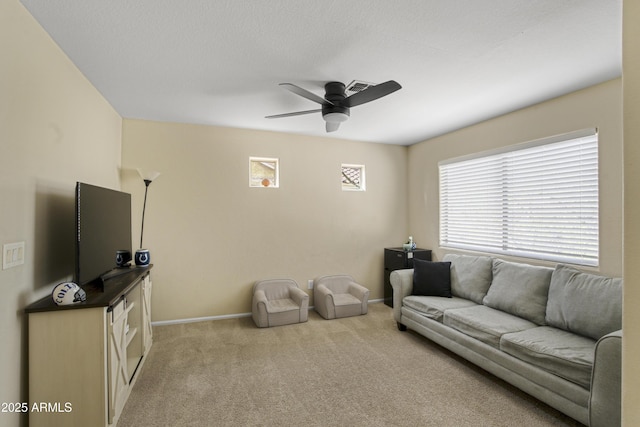 living room with visible vents, light colored carpet, baseboards, and a ceiling fan