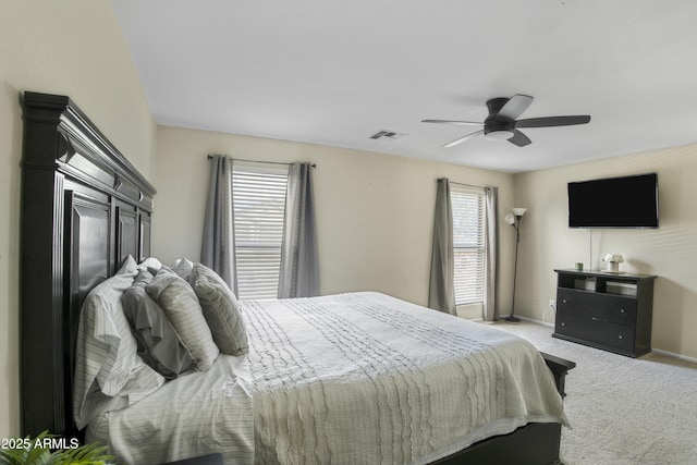 bedroom with visible vents, a ceiling fan, baseboards, and light carpet