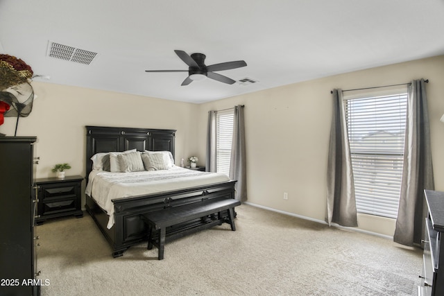 bedroom featuring visible vents, baseboards, light colored carpet, and a ceiling fan