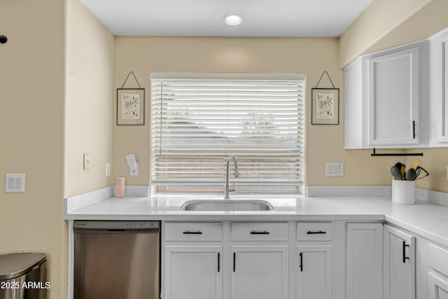 kitchen featuring dishwasher, light countertops, white cabinetry, and a sink