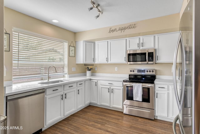 kitchen featuring white cabinetry, stainless steel appliances, light countertops, and a sink