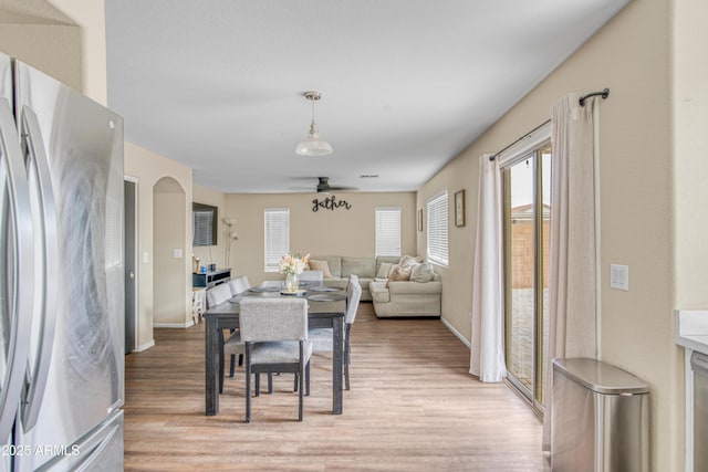 dining room with baseboards, light wood-type flooring, and ceiling fan