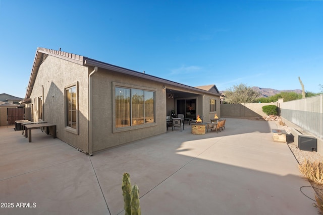 7145 E Cuernavaco Way, Gold Canyon, AZ 85118 - back of property featuring a fenced backyard, stucco siding, an outdoor fire pit, a patio, and a mountain view