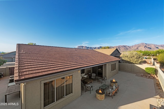 7145 E Cuernavaco Way, Gold Canyon, AZ 85118 - back of house featuring a patio area, a mountain view, a fire pit, and stucco siding