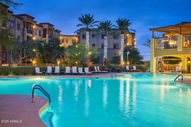 pool at dusk featuring a patio