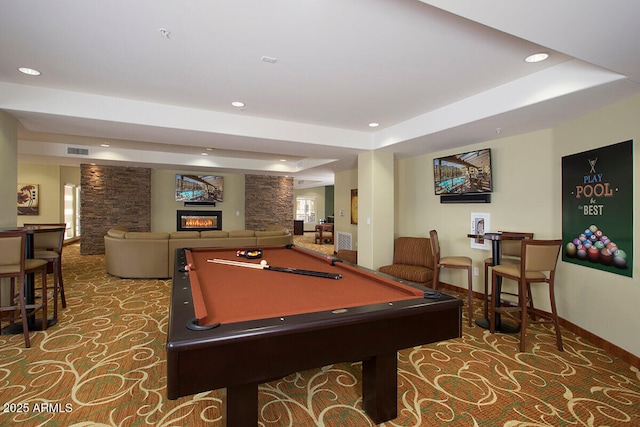 rec room featuring a tray ceiling, carpet flooring, a fireplace, and pool table