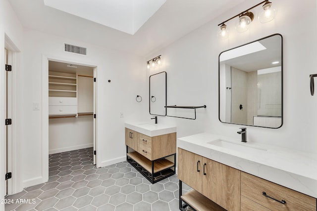 bathroom with a shower, tile patterned flooring, and vanity