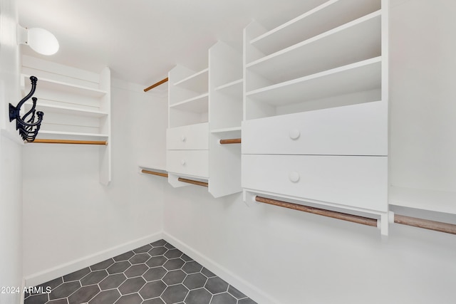 walk in closet with dark tile patterned floors