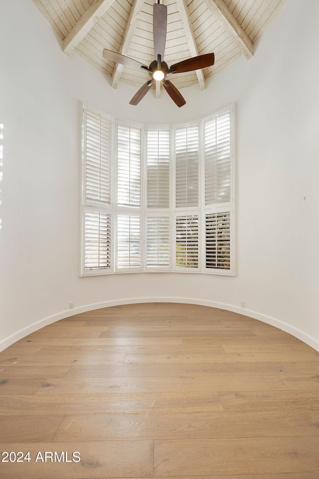 unfurnished room featuring ceiling fan, light hardwood / wood-style floors, wood ceiling, and lofted ceiling with beams